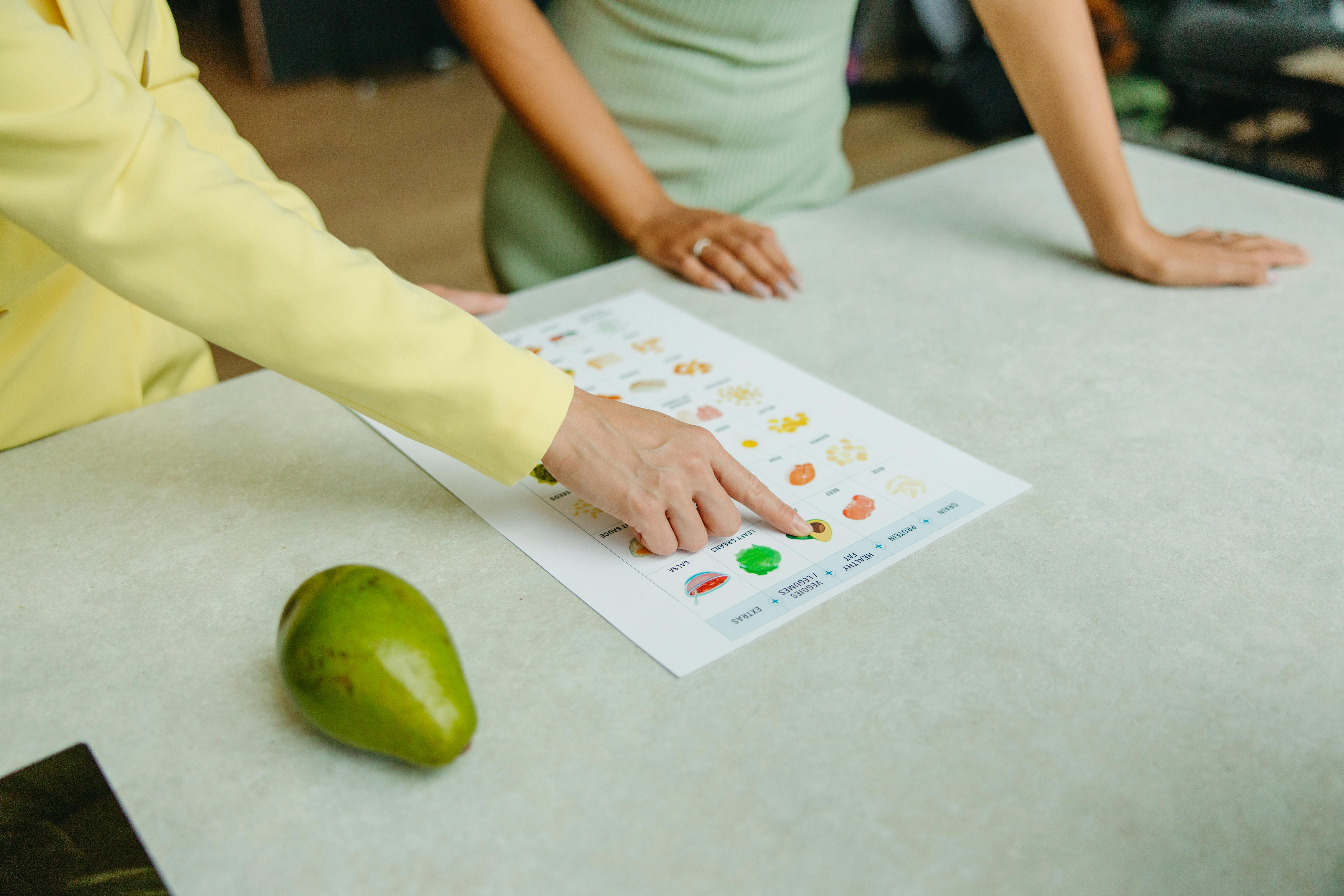 Two people consult a food table.